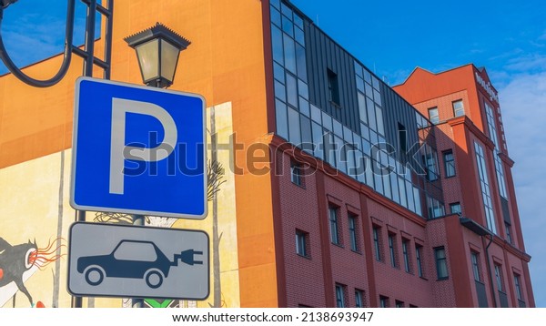 Electric\
Vehicle Recharge Point Sign and parking for electric car.\
Innovation concepts. Green energy. Charging station for electric\
vehicle with parking on building\
background.