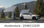 Electric vehicle recharges at a scenic charging station surrounded by mountains and nature, highlighting the integration of sustainable energy into modern mobility