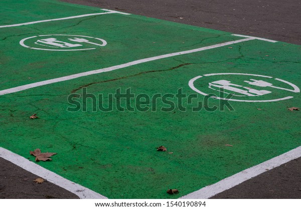 Electric vehicle refueling sign on asphalt.\
Road marking and sign of the charging point of several electric\
vehicles at the same time.. Top down\
view.