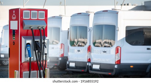 Electric Vehicles Charging Station On A Background Of A Row Of Vans. Concept