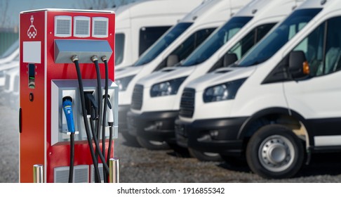 Electric Vehicles Charging Station On A Background Of A Row Of Vans. Concept