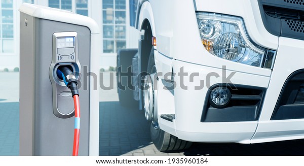 Electric vehicles charging station on a\
background of a truck.\
Concept