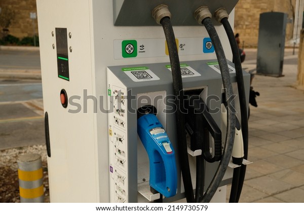 Рublic electric\
vehicles charging station. Power supply for charging an electric\
car. New energy vehicles, eco-friendly alternative energy for cars.\
Valetta, Malta - April,\
2022.