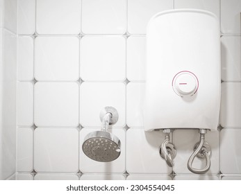 Electric water heater and shower in the bathroom. Closeup photo, blurred.