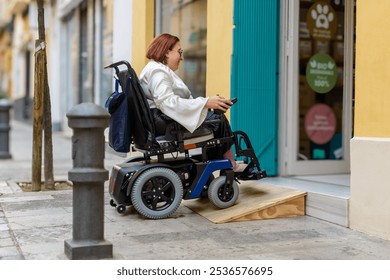 Electric wheelchair user successfully navigates a wooden ramp to access a store, demonstrating accessible architecture. - Powered by Shutterstock