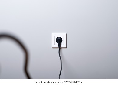 Electric white socket and one plugged in power cord on white wall background - Shutterstock ID 1222884247