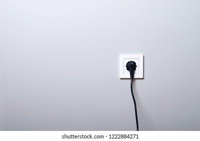 Electric white socket and one plugged in power cord on white wall background - Shutterstock ID 1222884271