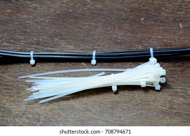 the electric wire and white  cable tie on wooden table