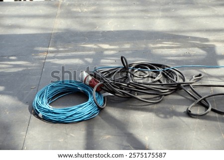 Electrical cables tangled on the ground during an outdoor event setup