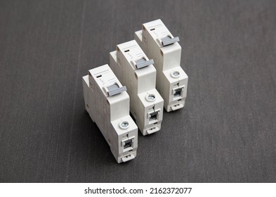 Electrical Circuit Breakers On A Gray Background, Close-up. Designed For Switching Electrical Circuits And Their Protection. Electromagnetic Short Circuit