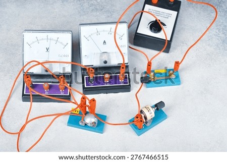 an electrical circuit consisting of a light bulb, an ammeter, voltmetr, a key and a current source