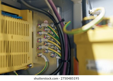 Electrical components connect inside a control panel in a utility room during daytime work hours