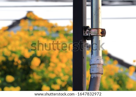 Electrical conduit for cable routing between electrical distribution panel with Pipe holder install outside the building.