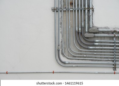 Electrical conduits system and metal pipeline installed on building ceiling.selective focus and background