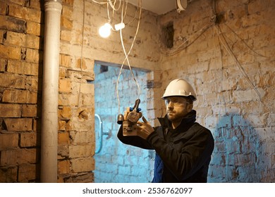 Electrical contractor working with cables on construction site during installation process. - Powered by Shutterstock