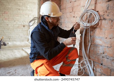 Electrical contractor working with multiple cables during installation precess inside home.