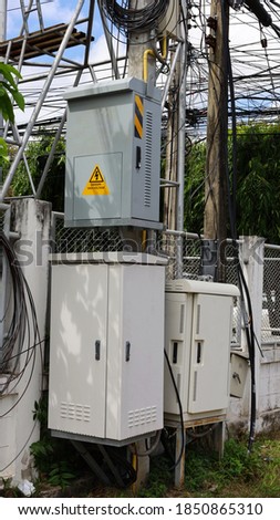 Electrical control socket and NODE cabinet on poles. Fiber optic junction box of high speed internet on the side with cement fence reinforced with steel frame. Selective focus