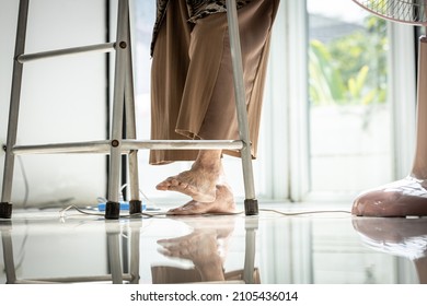 Electrical cord or socket cluttered on the floor,feet of senior grandmother stepping over obstacles,old elderly walking with difficulty in home,concept of danger,injury and risk of accident in falling