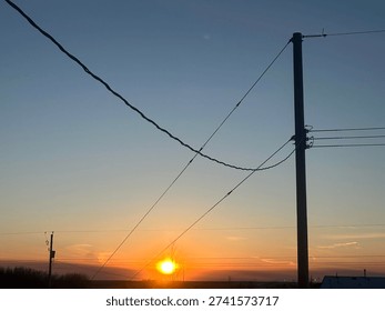 Electrical distribution lines crossing dramatic sunset horizon