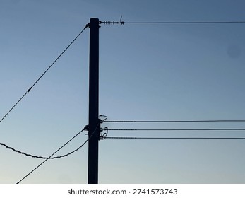 Electrical distribution lines crossing dramatic sunset horizon