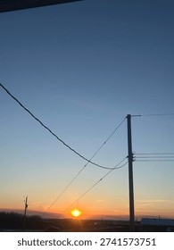 Electrical distribution lines crossing dramatic sunset horizon