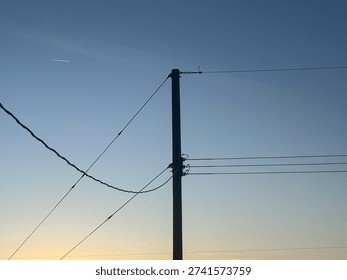 Electrical distribution lines crossing dramatic sunset horizon