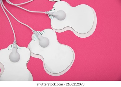 Electrical electrodes for stimulating the patient's body on a pink background.
