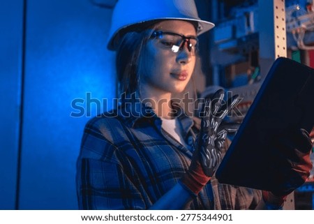 Electrical engineer analyzing power system on tablet near switchboard. Technical inspection.