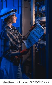 Electrical engineer analyzing system diagram near switchboard. Technical inspection.