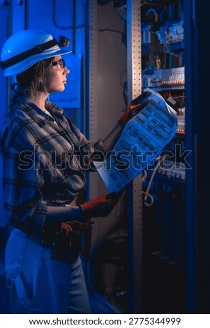 Electrical engineer analyzing system diagram near switchboard. Technical inspection.