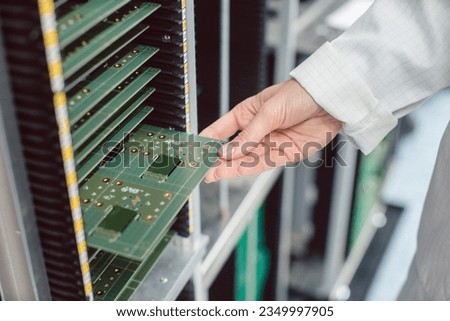 electrical engineer at assembly line inspecting PCB boards