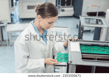 electrical engineer at assembly line inspecting PCB boards