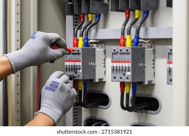 Electrical engineer checking the operation of electrical control cabinet, maintenance concept.	