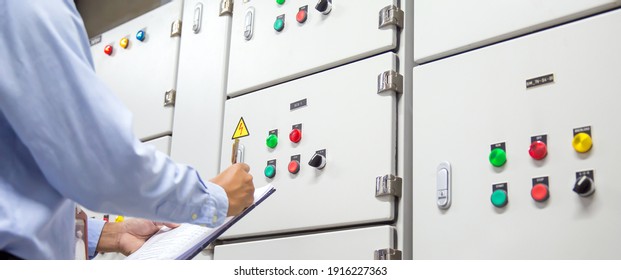 Electrical Engineer Checking Electrical Voltage At Circuit Breaker Air Handling Unit (AHU) Starter Control Panel For Air Conditioner Load Center Cabinet For Maintenance Power System Distribution.