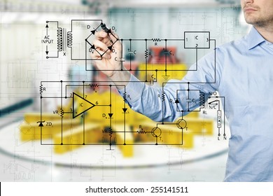 electrical engineer draws a diagram of a circuit. power plant interior in background