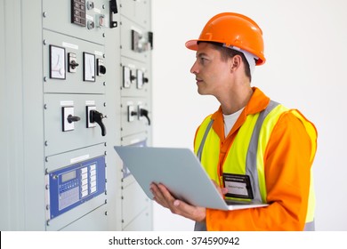 Electrical Engineer With Laptop Computer In Power Plant Control Room