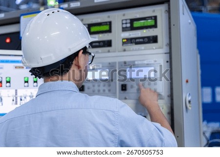 Electrical engineer male checking voltage at the Power Distribution Cabinet in the control room,preventive maintenance Yearly,inspecting power system and control panel in industrial factory