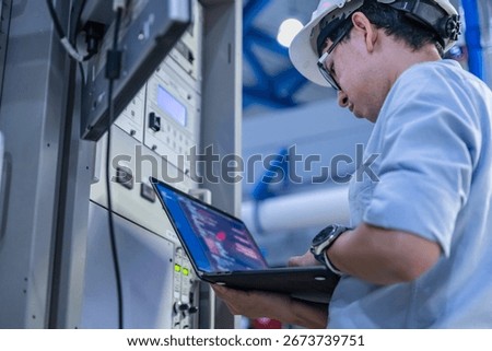 Electrical engineer male checking voltage at the Power Distribution Cabinet in the control room,preventive maintenance Yearly,inspecting power system and control panel in industrial factory