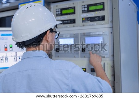 Electrical engineer male checking voltage at the Power Distribution Cabinet in the control room,preventive maintenance Yearly,inspecting power system and control panel in industrial factory