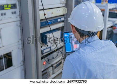 Electrical engineer male checking voltage at the Power Distribution Cabinet in the control room,preventive maintenance Yearly,inspecting power system and control panel in industrial factory