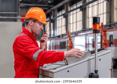 Electrical engineer railway checking construction process electric train and maintenance station .Engineer wearing safety uniform and helmet by using walki-talkie in work. transportation, transport.