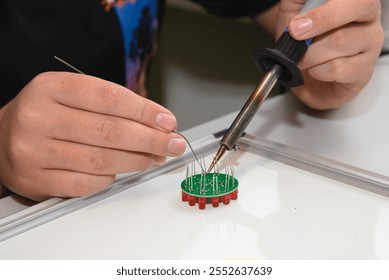 Electrical engineer solders electrical components - light-emitting diodes, closeup - Powered by Shutterstock