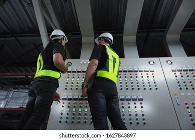 Electrical Engineer Team Working Front HVAC Control Panels, Technician Discussion And Training Daily Check Controls System For Security Functions In Service Room At Factory.