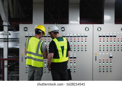 Electrical Engineer Team Working Front HVAC Control Panels, Technician Discussion And Training Daily Check Controls System For Security Functions In Service Room At Factory.