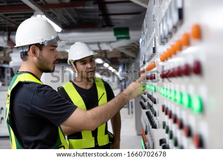 Electrical Engineer team working front HVAC control panels, Technician daily check controls system for security functions in service room at factory. Heating,Ventilation,Air Conditioning.