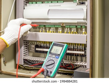 Electrical engineer tests the operation of the electric control cabinet on a regular basis for maintenance.