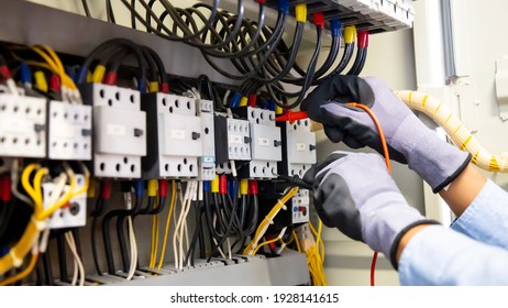 Electrical Engineer Using Digital Multi-meter Measuring Equipment To Checking Electric Current Voltage At Circuit Breaker And Cable Wiring System In Main Power Distribution Board.