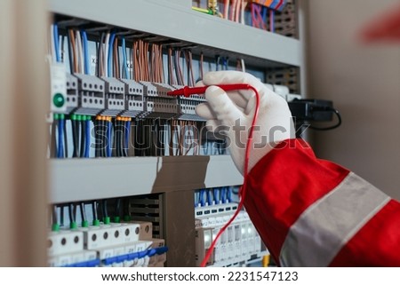 Electrical engineer using digital multimeter measuring equipment to checking electric current voltage.
