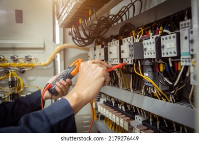 Electrical engineer using measuring equipment to checking electric current voltage at circuit breaker and cable wiring system , Electrical service concept .