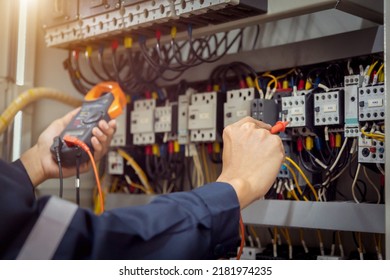 Electrical engineer using measuring equipment to checking electric current voltage at circuit breaker and cable wiring system , Electrical service concept . - Shutterstock ID 2181974235